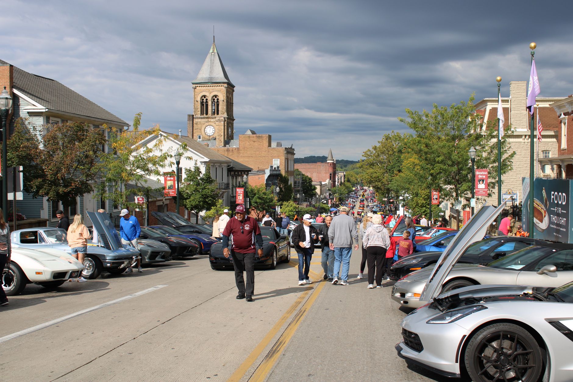 Crowds enjoy a vibrant car show on a sunny day in Lancaster, Ohio.