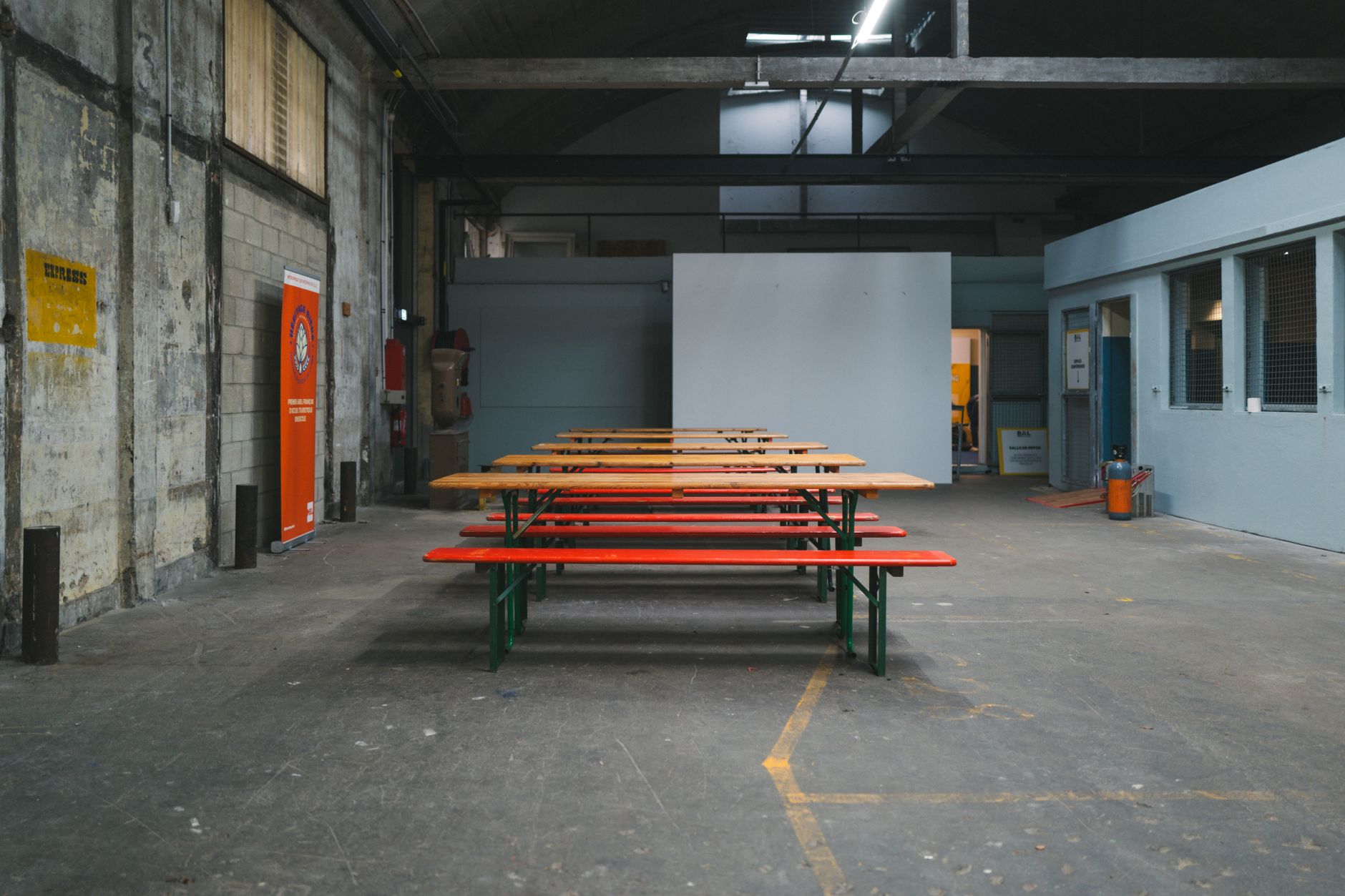 Empty industrial space with wooden benches, perfect for events or gatherings.